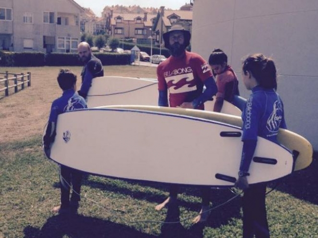  营地学生携带冲浪板 